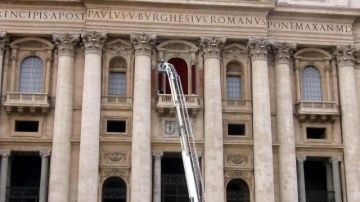 Varios omberos decoran con terciopelo rojo el balcón central de la Basílica de San Pedro, en la Ciudad del Vaticano, ayer, como decoración para la próxima presentación del nuevo papa.