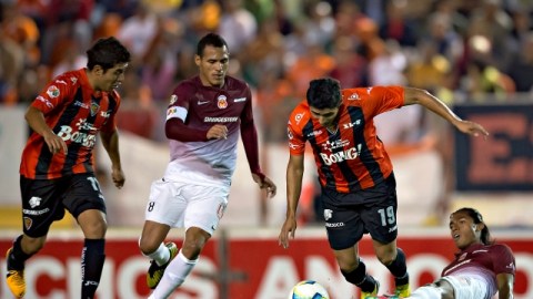 Édgar Andrade (19) deja tirado en el terreno de juego al defensa de Morelia Joel Huiqui (der.), ayer.