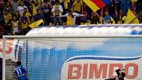El portero del América, Moisés Muñoz (centro), se lanza sin éxito para atajar un penal de Ezequiel Cuevas (11).