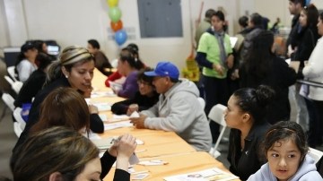 Familias reciben asistencia con la solicitud de seguro médico durante una reciente feria de salud.