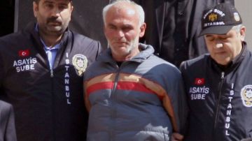 Policías sacan al sospechoso Ziya Tasali de una comisaría en Estambul este lunes, para ser llevado a la corte.