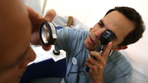 Un optometrista revisa los ojos de un paciente. Un senador propone que enfermeros y otros profesionales de la salud puedan ampliar su capacidad para atender a pacientes.