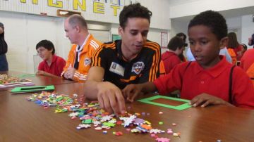Calen Carr, del Houston Dynamo, ayuda a alumnos de la primaria Rusk.