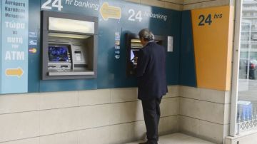 Un hombre retira dinero del cajero de la sucursal de un banco en Nicosia (Chipre).