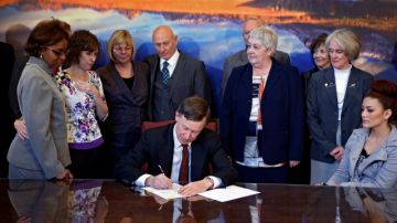El  gobernador John Hickenlooper (c) firmó ayer tres nuevas leyes para el control de armas de fuego.