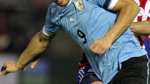 El jugador paraguayo Cristian Riveros (atrás) marca al uruguayo Luis Suárez, durante el partido en el Estadio Nacional de Montevideo.