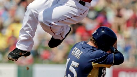 Howard Kendrick, salta para evitar la barrida de Caleb Gindl, de Milwaukee.