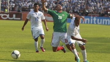 Los jugadores de Honduras Arnol Peralta (d) y Mario Martínez (i) disputan el balón con Jorge Torres Nilo (c) de México.