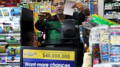 Baiju Amin le  vende un boleto de  lotería a un cliente en Totowa,  NJ.