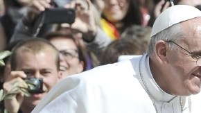 El papa Francisco, en su primera celebración de Semana Santa, bendice a una niña cuando saluda a los fieles al final del Domingo de Ramos, en la Plaza de San Pedro, ayer.