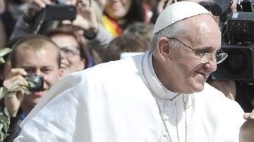 El papa Francisco, en su primera celebración de Semana Santa, bendice a una niña cuando saluda a los fieles al final del Domingo de Ramos, en la Plaza de San Pedro, ayer.