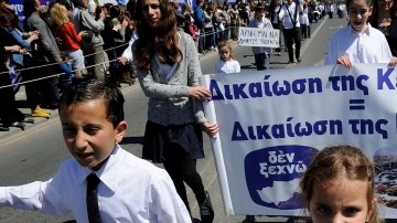Estudiantes llevan un rótulo que dice 'Chipre no está en venta' mientras participan en un desfile en Limassol, Chipre.