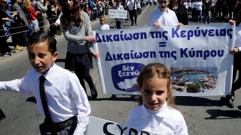 Estudiantes llevan un rótulo que dice 'Chipre no está en venta' mientras participan en un desfile en Limassol, Chipre.