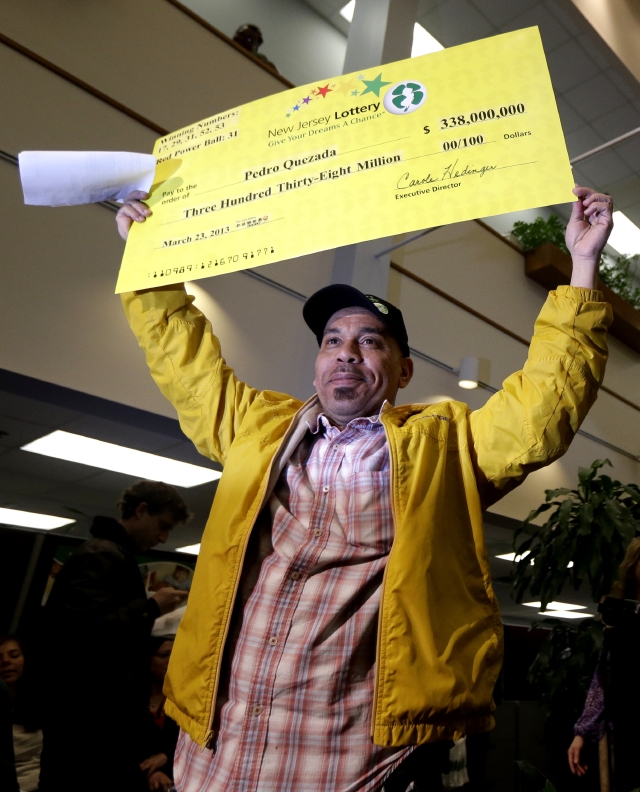 Pedro Quezada,  ganador del  Powerball, sostiene el cheque promocional por la cantidad de $338 millones, en New Jersey.