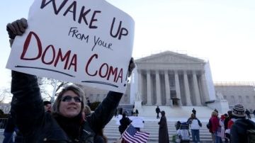 Una partidaria de los matrimonios de personas del mismo sexo, Carolyn Marosy, sostiene un cartel en el que se lee "¡Despertad de vuestro DOMA coma!"), " ante el Tribunal Supremo de Estados Unidos en Washington DC.