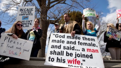 Allan Hoyle of North Carolina, with the large white sign, center, speaks out against gay marriage across from the street from the Supreme Court in Washington, Wednesday, March 27, 2013, after the court heard arguments on the Defense of Marriage Act (DOMA) case. The U.S. Supreme Court, in the second day of gay marriage cases, turned Wednesday to a constitutional challenge to the federal law that prevents legally married gay Americans from collecting federal benefits generally available to straight married couples. (AP Photo/Carolyn Kaster)