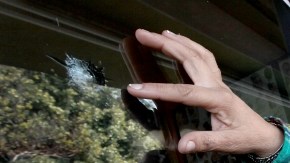 Yosie Reynaga muestra los impactos de bala en su negocio. Ella es una de las candidatas al nuevo distrito de Compton.