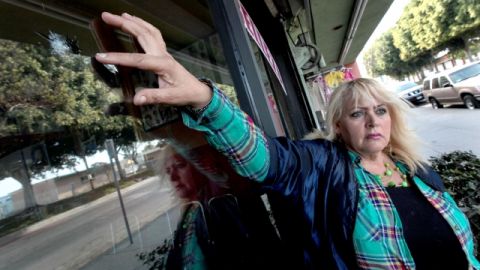 Yosie Reynaga muestra los impactos de bala en su negocio. Ella es una de las candidatas al nuevo distrito de Compton.