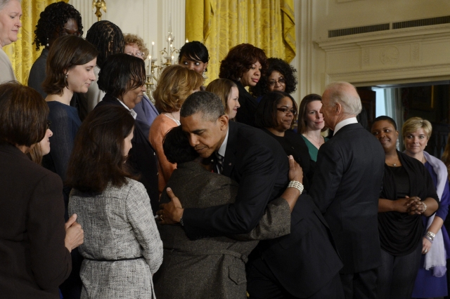 El presidente Barack Obama (i) y el vicepresidente Joe Biden (d) abrazan a varias personas afectadas por tiroteos.