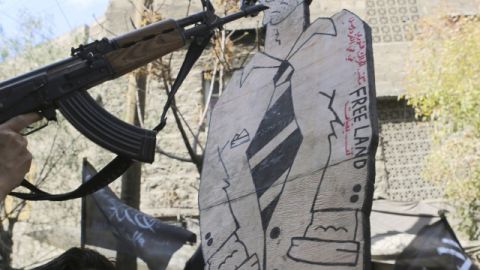 Apuntan con un arma a la figura de Al Assad, en Alepo, ayer.