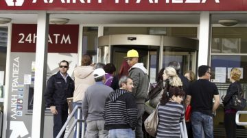 Varias personas hacían cola a las puertas de una sucursal del Banco Laiki en Nicosia (Chipre), el viernes.