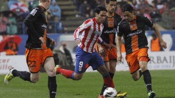 Radamel Falcao (centro), volvió a anotar, pero Atlético de Madrid no pasó del empate ante Valencia.