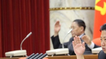 El líder norcoreano Kim Jong-un levanta su mano, junto a otros miembros partidistas, para aprobar una declaración sobre las reglas del Partido de los Trabajadores, en un plenario del Comité Central.