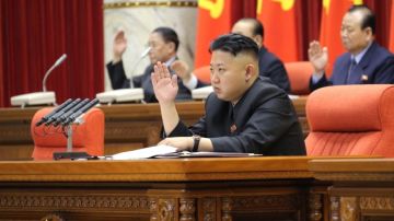 El líder norcoreano Kim Jong-un levanta su mano, junto a otros miembros partidistas, para aprobar una declaración sobre las reglas del Partido de los Trabajadores, en un plenario del Comité Central.
