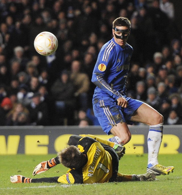 Fernando Torres, usando un protector especial en su rostro, vence al arquero Sergei Ryzhikov en el Estadio Stamford Bridge en Londres.