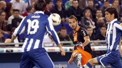 Roberto Soldado, realiza un disparo entre los jugadores del Espanyol,  Diego Colotto y Juan Forlín.