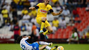 Miguel Layún, autor del gol del empate del América, evita la barrida de Pablo Gonzaléz ayer en el Estadio Azteca.