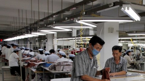 Dos hombres norcoreanos trabajan en el complejo industrial de Kaesong, donde elaboran prendas de vestir. La mayor parte de los empleados son mujeres.