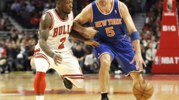 Jason Kidd, de los Knicks, trata de pasar la férrea marca de Nate Robinson, el héroe del juego de anoche para los Toros.