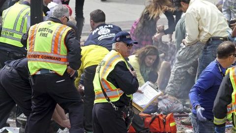 Rescatistas atienden a un herido después de la explosión en la línea de meta de la edición 117 del Maratón de Boston en Boston (EE.UU.).