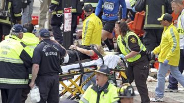 Rescatistas atienden a un herido después de la explosión ayer en el maratón de Boston.
