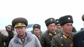 El líder norcoreano Kim Jong Un, centro, camina con una unidad militar tras su arribo a Mu Islet, localizado en el suroeste de la frontera con Corea del Sur.