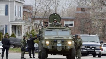 Vehículos militares y de los cuerpos de emergencia recorren las calles de Watertown, cerca de Boston.