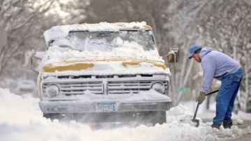 Bob Hanks removía nieve ayer viernes    para poder conducir su camioneta que quedó atrapada frente a su casa de St. Cloud, Minnesota.