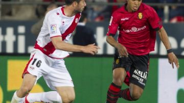 Giovani Dos Santos (der.), toma ventaja sobre el defensor     Jordi Amat del Rayo Vallecano en el partido que abrió la jornada de Liga.