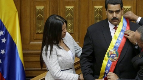 La hija del expresidente Chávez, Maria Gabriela, y el presidente de la Asamblea Nacional, Diosdado Cabello, colocan la banda presidencial a Nicolás Maduro.