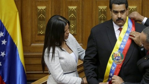 La hija del expresidente Chávez, Maria Gabriela, y el presidente de la Asamblea Nacional, Diosdado Cabello, colocan la banda presidencial a Nicolás Maduro.
