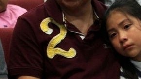 El mexicano Eduardo Mireles Salazar sostiene una pancarta de súplica junto a su nieta Sharytin Hernández, de ocho años, durante una vigilia en Charlotte.