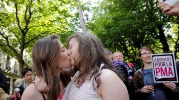 Dos mujeres se besan frente a la sede del parlamento en Paris.