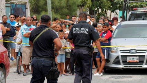Policías aseguran el lugar donde encontraron los cadáveres de cinco hombres y dos mujeres en el interior de una casa en un barrio de bajos ingresos en la ciudad turística de Cancún, México, el domingo 14 de abril 2013.