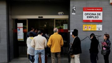 Decenas de españoles esperan en una oficina de empleo ante el aumento histórico del desempleo en ese país.