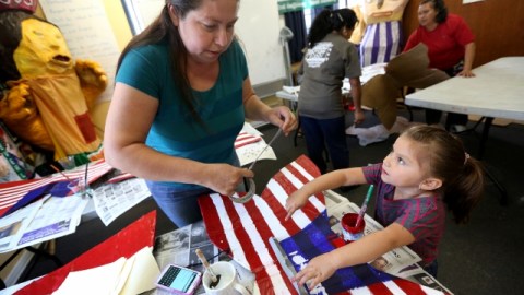 Rosa Villaseñor con su hijita de 4 años, Sasha Carmen, pintan mariposas con los colores de la bandera de Estados Unidos en las oficinas de KIWA, para participar en la marcha del 1ro de mayo.
