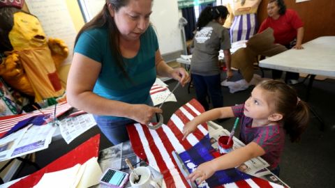 Rosa Villaseñor con su hijita de 4 años,  Sasha Carmen,  pintan mariposas con los colores de la bandera de Estados Unidos en las oficinas de  KIWA, para participar en la marcha del 1ro de  mayo.