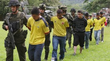 Miembros de la policía custodiaban  a 17 presuntos guerrilleros de las FARC, en Cali (Colombia), ayer.