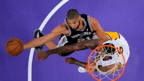 Tim Duncan (21) intenta encestar la bola ante la marca de Earl Clark en el cuarto juego de ayer.