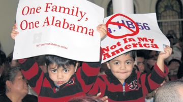 Dos niños sostienen unos carteles durante un mitín en Birmingham, Alabama, para exigir la revocación de la ley HB56 que criminaliza a los inmigrantes indocumentados en Alabama.